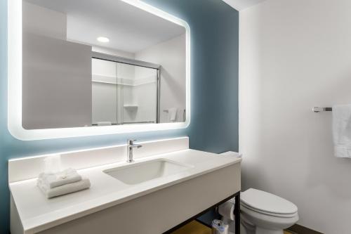 a white bathroom with a sink and a mirror at StudioRes by Marriott Newnan in Newnan