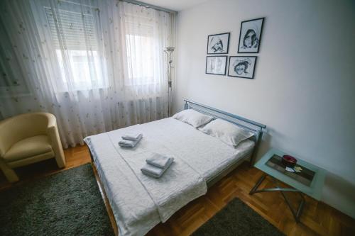 a bedroom with a bed with two towels on it at Apartment Stela in Belgrade