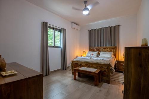 a bedroom with a bed and a table and a window at Pro Cab Apartment - Washer - BBQ in Cabarete