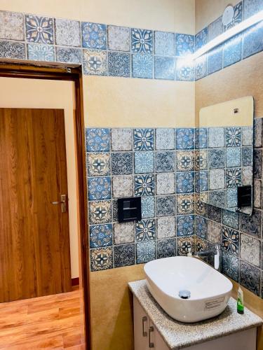 a bathroom with a sink and blue tiles on the wall at Mananjay Natures Retreat in Jāmb