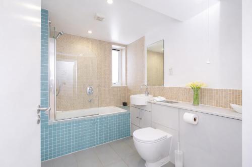 a bathroom with a toilet and a tub and a sink at Roomspace Serviced Apartments - Kew Bridge Court in London