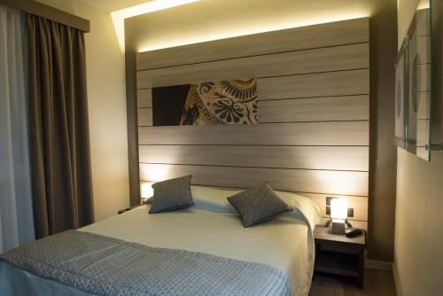 a bedroom with a large bed and a mirror at Archeo Hotel in Gela