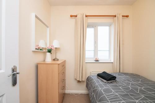 a bedroom with a bed and a window at 6 bed house with free secure parking & 3 bathrooms in Wolverhampton