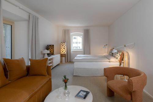 a hotel room with two beds and a living room at Hôtel Bodenhaus in Splügen