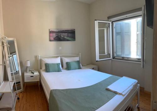 ein Schlafzimmer mit einem großen weißen Bett und einem Fenster in der Unterkunft Laundry House in Sinarádes