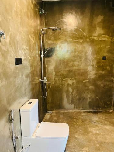 a bathroom with a toilet and a shower at Mama Place in Hikkaduwa