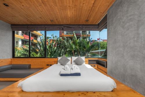 a bedroom with a large bed with two towels on it at Relife Apartments by Tropiclook - Fast WiFi , Pool and Gym in Phuket