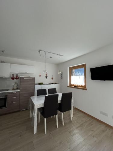 a kitchen and dining room with a table and chairs at Bormio suite apartment, terme e sci a 5 min. di auto in Valdisotto