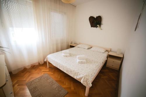 a small bedroom with a bed and a window at Viktorija Apartment in Belgrade