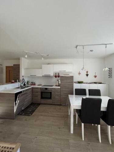 a white kitchen with a white table and chairs at Bormio suite apartment, terme e sci a 5 min. di auto in Valdisotto