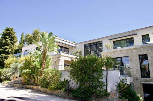 an apartment building with trees in front of it at HPC Suites - Cassis Centre - Parking Securisé et Piscine Chauffée in Cassis