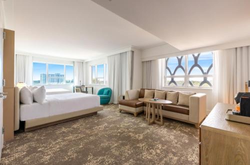 a hotel room with a bed and a couch at Eden Roc Miami Beach in Miami Beach