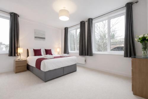 a bedroom with a bed and two windows at Roomspace Serviced Apartments - Nouvelle House in Sutton