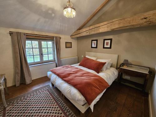 a bedroom with a large bed and a window at Gîte de la petite touche in Seligny