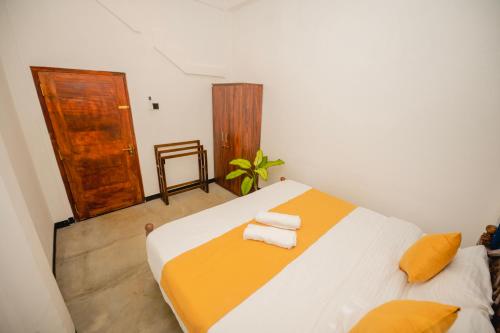 a bedroom with a bed with towels on it at Enu Homestay in Dickwella