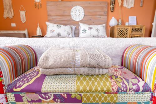 a bed with a pile of blankets and pillows on it at La Matassina Tuscany in Castellina Marittima