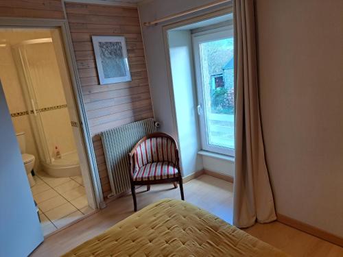 a bedroom with a chair and a window and a toilet at Kerioret Izella in Kerlaz
