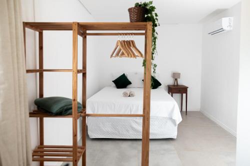 a bedroom with a wooden bunk bed with white sheets at Kicoh - Kite Community House in Itarema