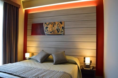a bedroom with a headboard and a bed with two pillows at Archeo Hotel in Gela