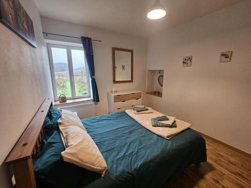 a bedroom with a bed with a blue blanket at Émeraude in Voulême