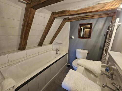 a bathroom with a tub and a toilet at Le logis in Mairé