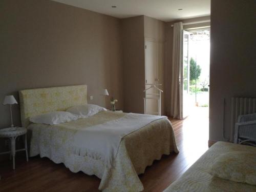 a bedroom with two beds and a large window at La pocterie in Vouneuil-sur-Vienne