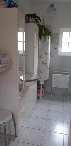 a kitchen with a refrigerator and a tiled floor at La cornouillère in Champau