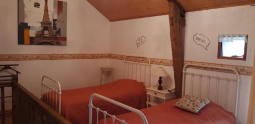 a bedroom with two beds and the eiffel tower on the wall at La cornouillère in Champau