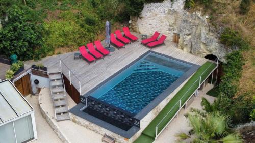 an overhead view of a swimming pool with red chairs at Gite 24 in Beaumont
