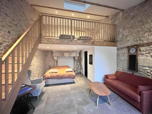 a bedroom with a bed and a staircase in a room at Gite 24 in Beaumont