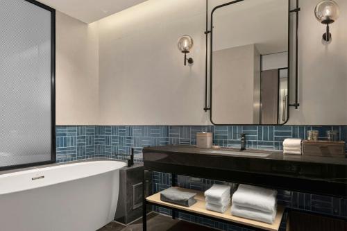 a bathroom with a tub and a sink and a mirror at Four Points by Sheraton Xi'an Bell Tower in Xi'an