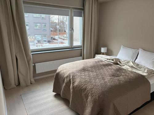 a bedroom with a bed and a large window at Bexam Apartment in Växjö