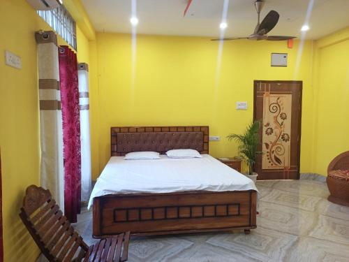 a bedroom with a bed and two chairs at DENEVA Inn in Nowgong