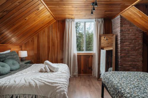 a bedroom with a bed and a window in it at Chalet rustique, Lac paisible, Canot, Famille in La Conception