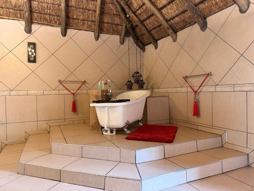 a bathroom with a tub and a red rug at Accommodation At Thabong in Brakpan