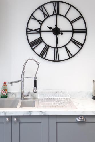 a clock on the wall above a kitchen sink at Runswick Road in Bristol