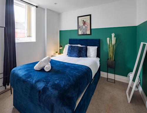 a bedroom with a large bed with blue and green walls at Runswick Road in Bristol