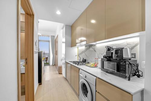 a kitchen with a microwave and a stove top oven at Waves - Modern & Vibrant Studio With Skyline View in Sabkhah
