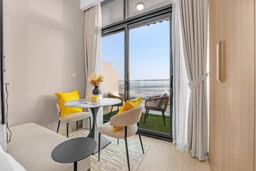 a room with a table and chairs and a window at Waves - Modern & Vibrant Studio With Skyline View in Sabkhah