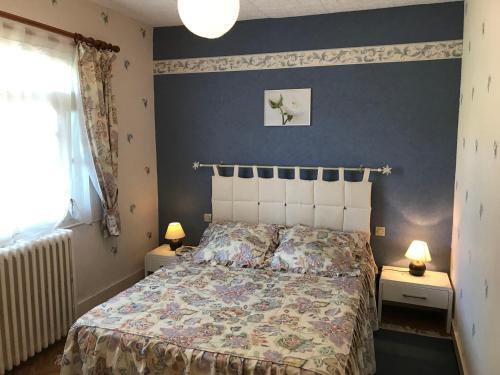 a bedroom with a bed and two night stands with lamps at La forge de louis in Saint-Macoux