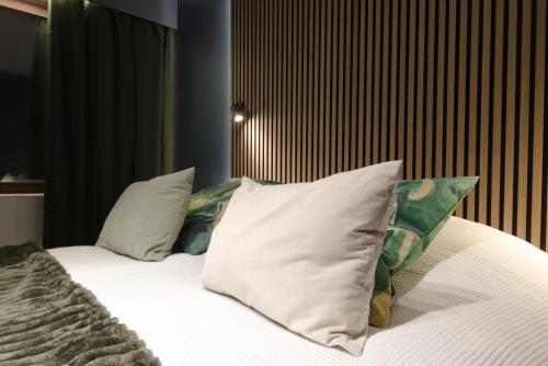 a bed with white sheets and pillows in a room at Hotel & Resort Sallavalkea in Salla