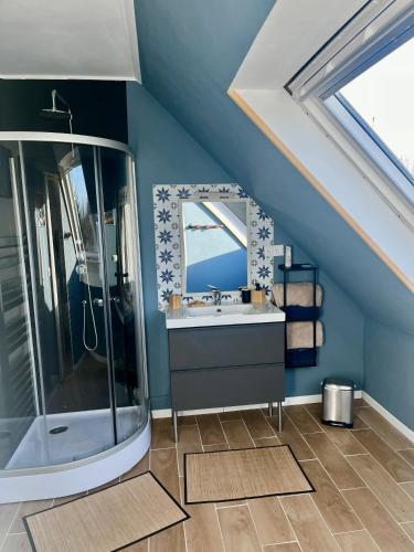 a blue bathroom with a sink and a shower at Rose et violette in Brélès