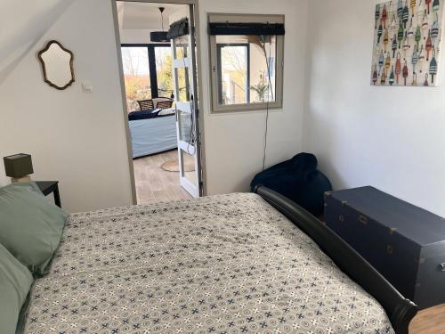 a bedroom with a bed and a mirror and a door at Rose et violette in Brélès