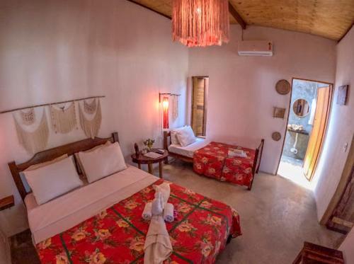 a bedroom with a large bed and a living room at Casa do Francês in Japaratinga