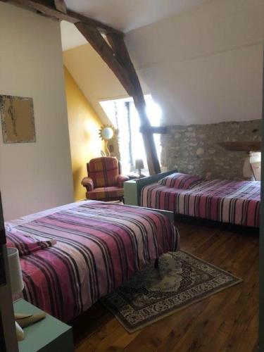 a hotel room with two beds and a chair at Le ry de pouzioux in Chauvigny
