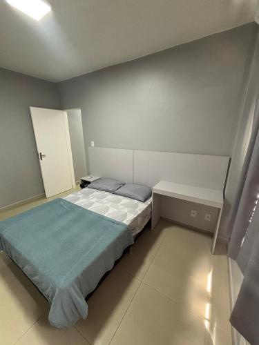a small bedroom with a bed and a cabinet at Apartamento no centro de Cuiaba até 3 pessoas in Cuiabá