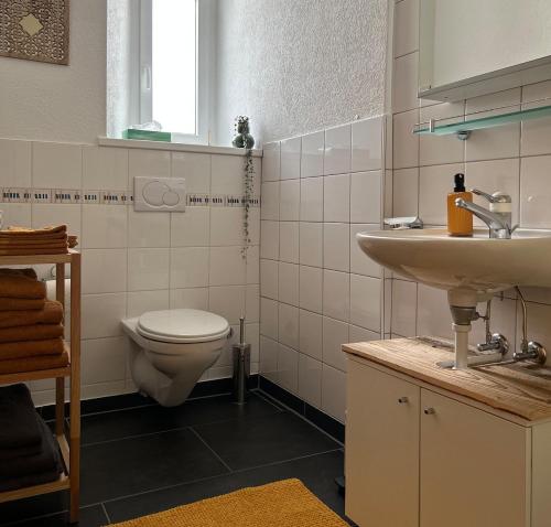 a bathroom with a white toilet and a sink at Appartement Atelier in Le Noirmont