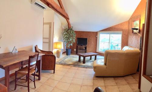 a living room with a table and a dining room at Les trois rivières in Persac