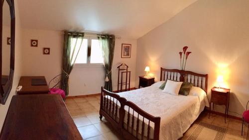 a bedroom with a bed and a table and a window at Les trois rivières in Persac