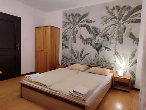 a bedroom with a bed with a tropical wallpaper at Młyn Warmiński -Hotelik Hermes in Pieniężno